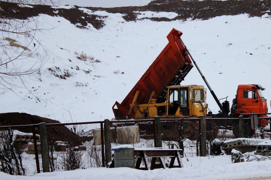 Грунт на отсыпку склонов на закрытом полигоне «Воловичи» завозят со стройплощадки новой школы
